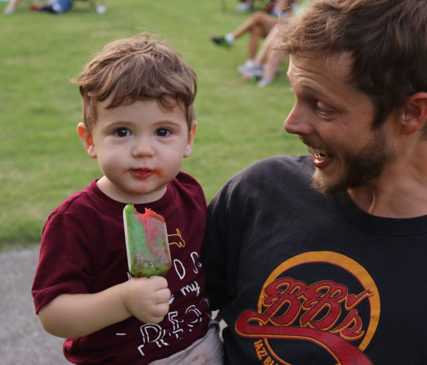 father with young boy eating popsicle